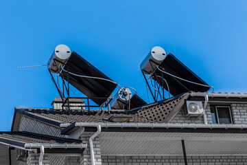 Thermal solar panels and water heater alternative technologies of water heating on the roof of the home against the blue sky outdoor