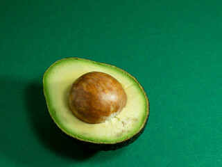 Fresh organic avocado on a green background.