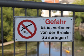 Schild: " Es ist verboten von der Brücke zu springen. Gefahr."