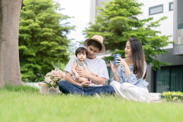 Asian Parents and a kid child playing in the garden at home. Family concept.
