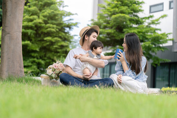 Asian Parents and a kid child playing in the garden at home. Family concept.