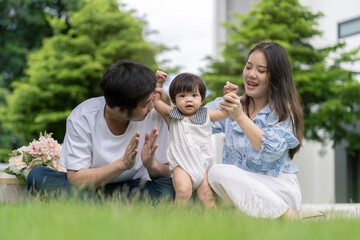 Fototapeta premium Asian Parents and a kid child playing in the garden at home. Family concept.