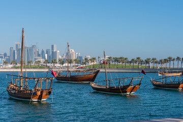 Obraz premium Traditional Arabic Dhow boats with the view of modern buildings in Doha, Qatar