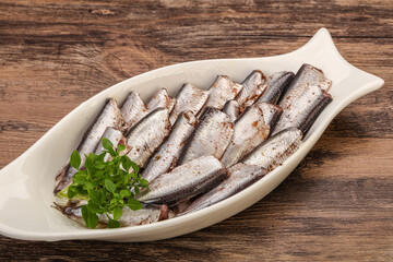 Anchovies in the bowl served basil leaves
