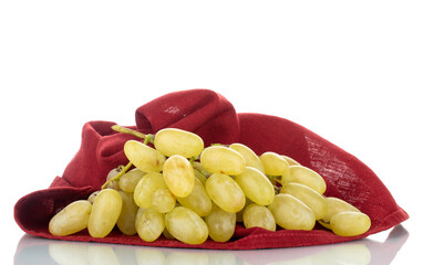 One bunch of organic juicy green grapes with a red linen napkin, close-up, isolated on white.
