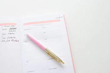 Planner for new years resolutions. Pink planner on a white desk. 