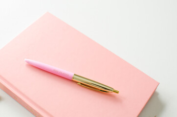 Planner for new years resolutions. Pink planner on a white desk. 