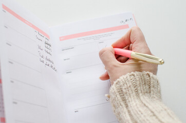 Planner for new years resolutions. Pink planner on a white desk. 