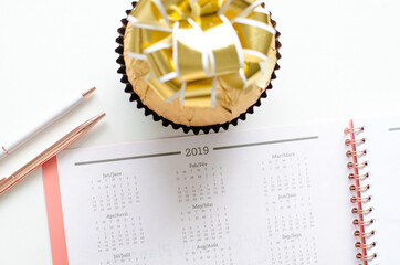 Planner for new years resolutions. Pink planner on a white desk. 