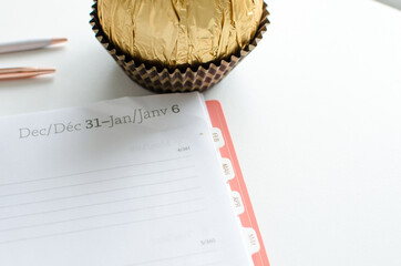 Planner for new years resolutions. Pink planner on a white desk.  - Powered by Adobe