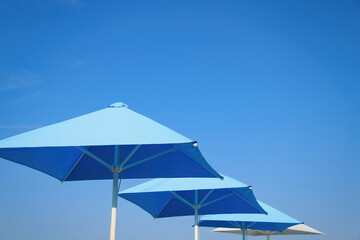 Bright beach umbrellas against blue sky on sunny day