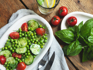 Salad. Fresh vegetable salad with tomato, cucumber, basil, green peas.