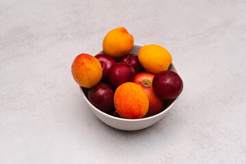 Fruit in a plain light bowl on a plain surface. Healthy vegetarian food