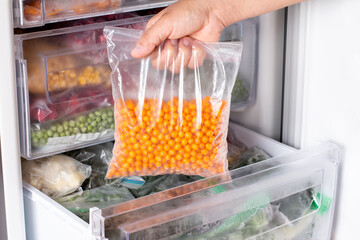 Frozen sea buckthorn in the freezer. Frozen berries.