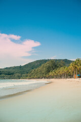 Beach with coconut trees and mountains.View of the coast of the island of island.