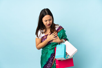 Young Indian woman with shopping bags having a pain in the heart