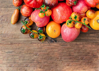 freshly picked tomatoes of different varieties on a wooden table