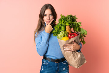 Young Lithuanian woman holding a grocery shopping bag thinking