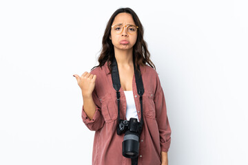 Young photographer woman over isolated white background unhappy and pointing to the side