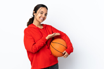 Young woman playing basketball over isolated white background presenting an idea while looking smiling towards