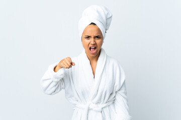 Young woman in bathrobe over isolated white background frustrated and pointing to the front