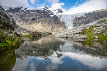Fototapeta na wymiar Mountain Glacier in alpine valley reflected in water. Schlaten Glacier, German: Schlatenkees, Hohe Tauern National Park, East Tyrol, Austrian Alps
