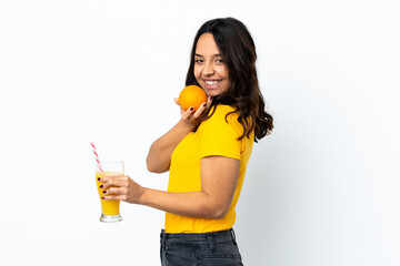 Young woman over isolated white background holding an orange and an orange juice