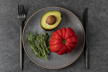 Fresh vegetables on a grey platter, table setting in dark colours. Healthy eating and diet concept.