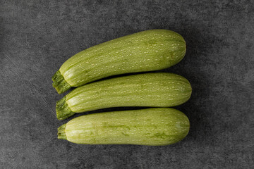 Homegrown zucchini on a gray background. Top view. Healthy food concept.