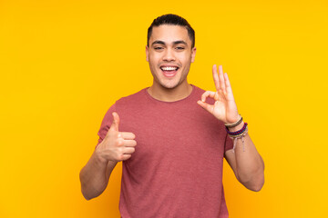 Asian handsome man isolated on yellow background with surprise expression while looking side