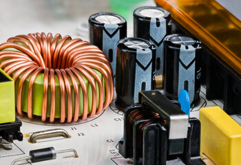 Toroidal core inductor, transformer or electrolytic capacitors on PCB detail. Close-up of coil...