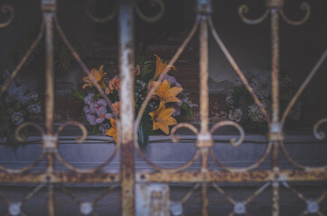 All Saints Day in the cemetery, grave behind iron rusty gate