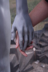 girl holding a statue by the hand