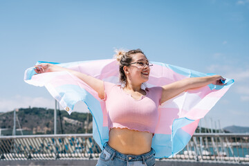transsexual woman with trans flag, holding a transgender pride flag