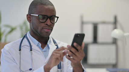 Obraz na płótnie Canvas African Doctor using Smartphone in Clinic