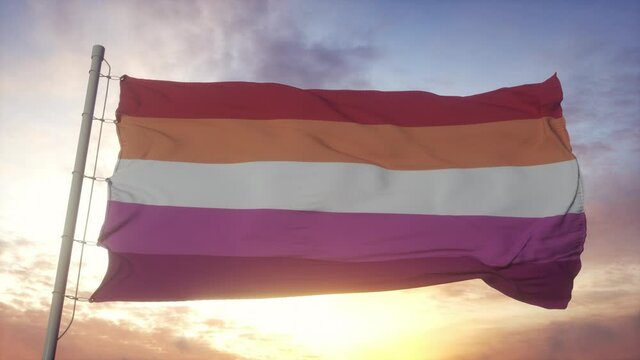 Lesbian pride flag waving in the wind, sky and sun background