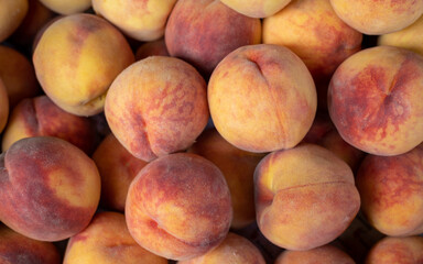 Peach closeup background on a farmers market stand with lots of peaches.