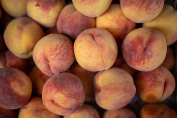 Peach closeup background on a farmers market stand with lots of peaches.