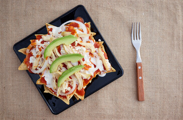 Chilaquiles rojos con pollo y aguacate comida tradicional mexicana en el desayuno o comida.