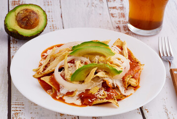 Chilaquiles rojos con pollo y aguacate comida tradicional mexicana en el desayuno o comida.