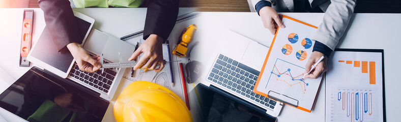 engineer working at a drawings of house in office for discussing. Engineering tools and...