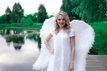 portrait of blonde woman in white dress and white angels wings. good people. heaven, god. paradise angel.