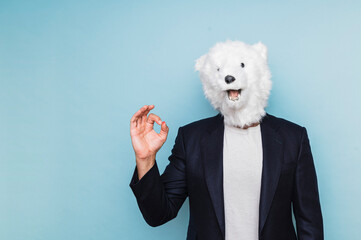 Man with polar bear mask making OK gesture. - obrazy, fototapety, plakaty