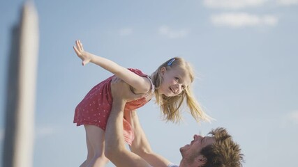 Slow motion - Young dad holding up her little girl