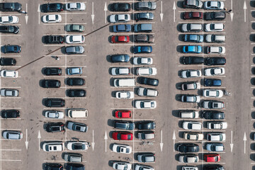 Parking lot with many parked cars at business center or mall, aerial view. City transportation concept.