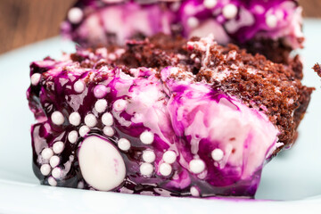 Obraz na płótnie Canvas chocolate cake with cream covered with blueberry jam