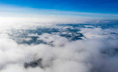 An amazing aerial shot of a winter landscape above the clouds.