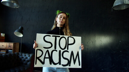 White activist girl protesting with stop racism sign 