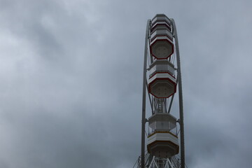 Ferris wheel spinning in an amusement park. Fairground ride.  Cabins of the ferris wheel. 