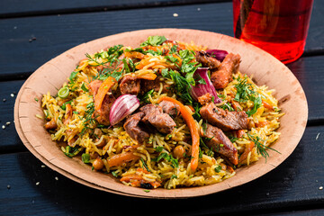 pilaf with lamb, Pilaf on plate on a dark wooden background